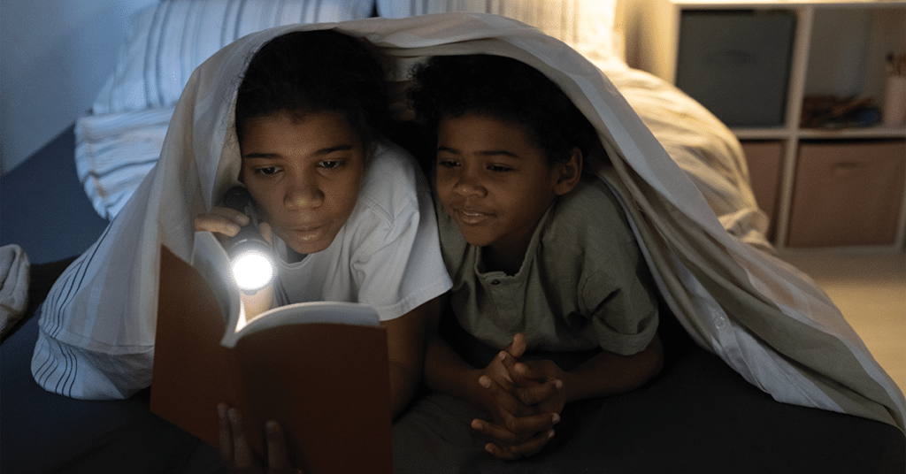 kids reading book with flashlight 2021 12 09 13 55 03 utc
