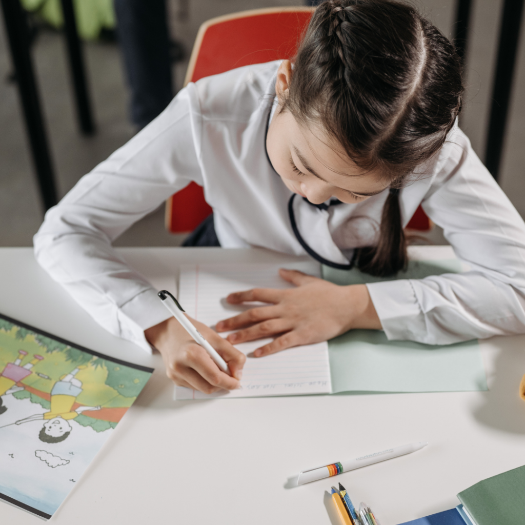 a girl writing at a desk