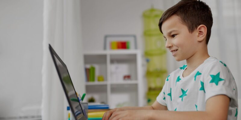 smiling boy working on laptop