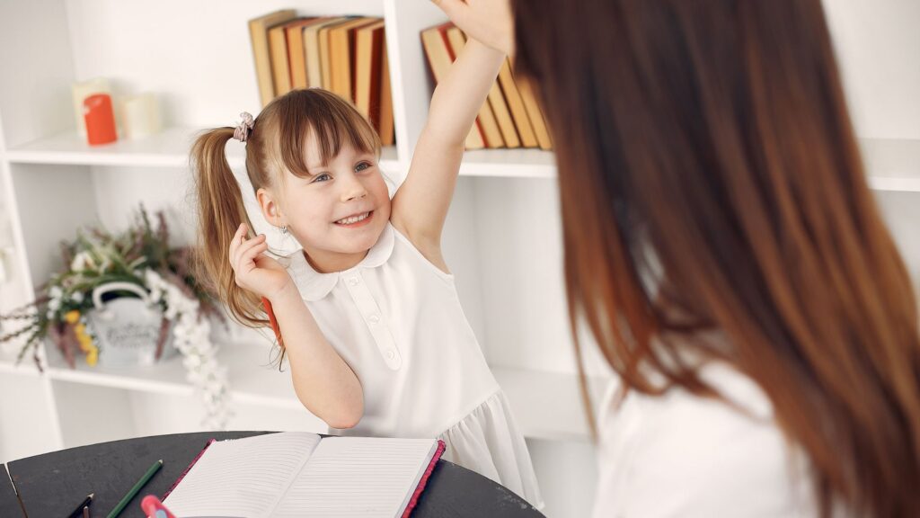 young girl smiling during a writing lesson