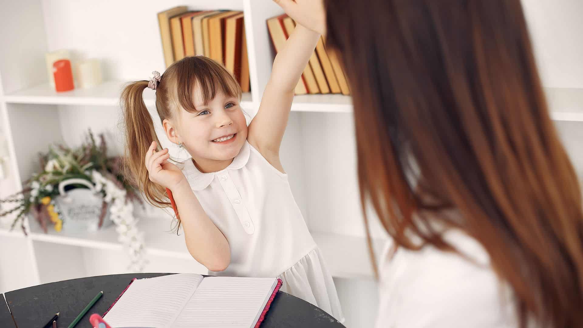 young girl smiling during a writing lesson