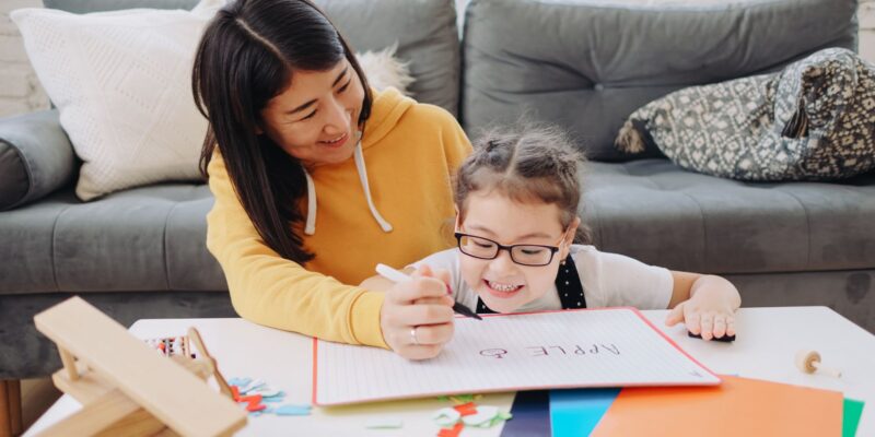 A child and parent doing homeschool together